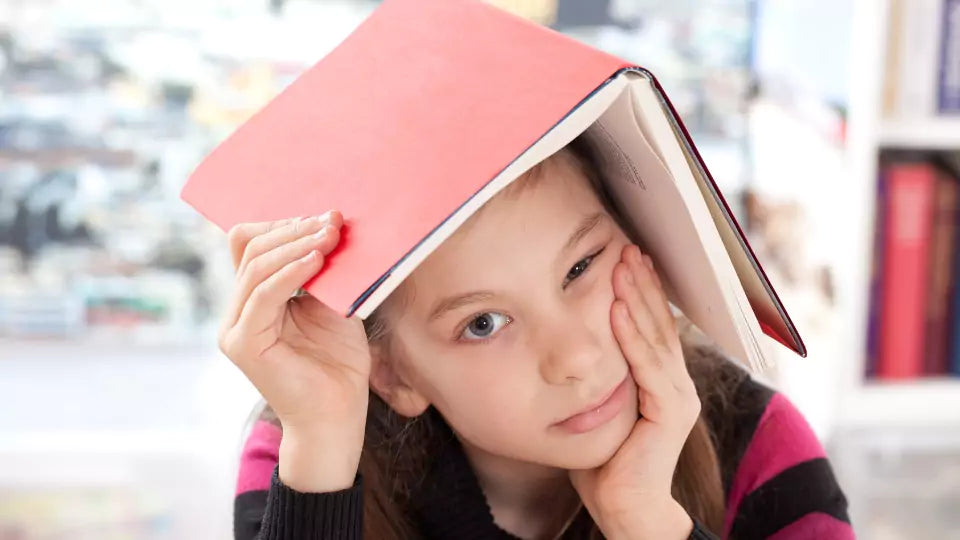 Jente med en skrivebok på hodet