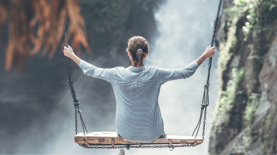 Kvinne svinger på en huske og er i balanse 