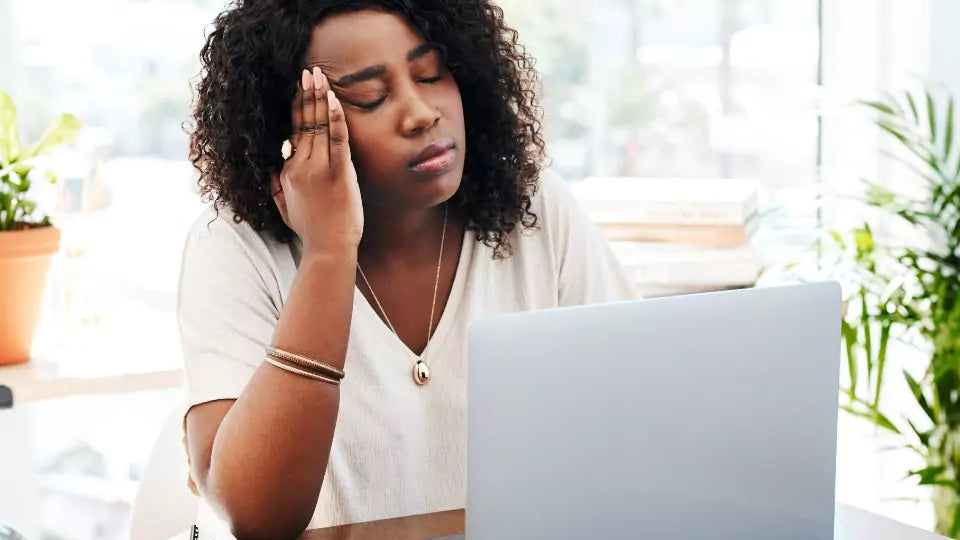 Kvinne holder hånden mot hodet